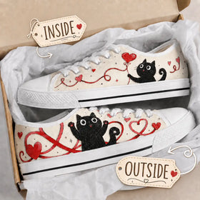 Pair of Black Cat Heart sneakers with cream-toned uppers